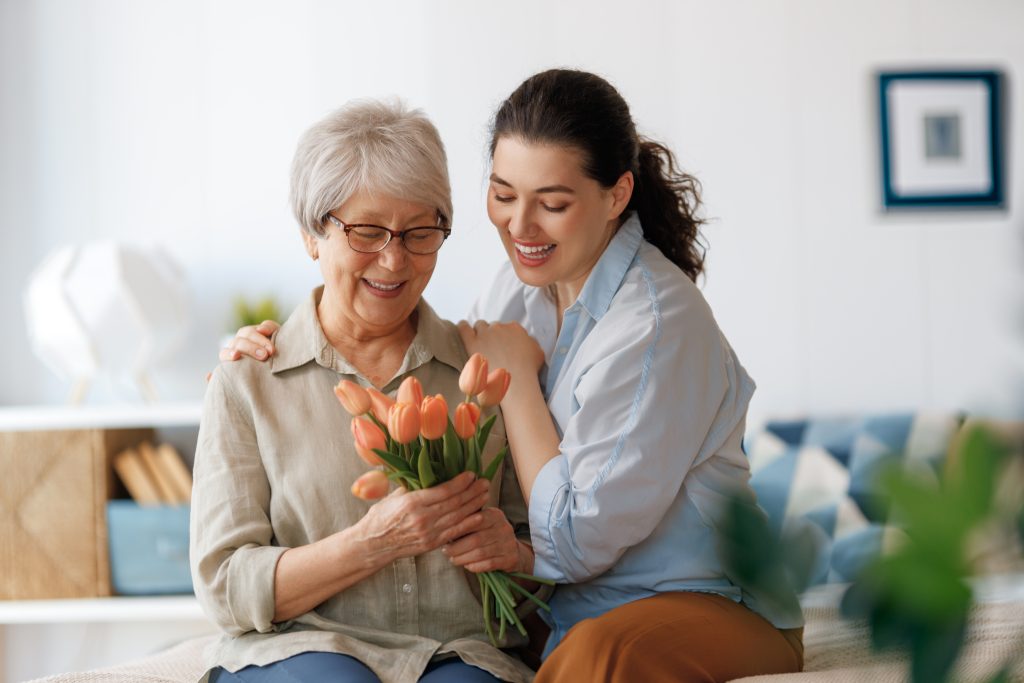 Mother receiving flowers from her teenage child as a Mother's Day gift